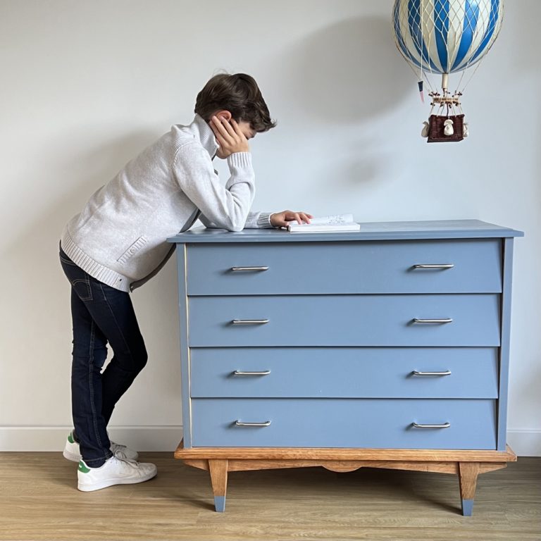 garçon lisant dans sa chambre sur une commode scandinave relookée