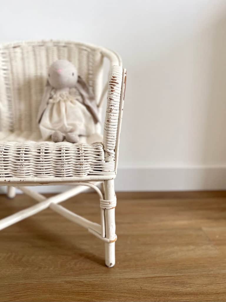 lapin en peluche sur un fauteuil pour enfant vintage blanc et patiné en décoration d'une chambre d'enfant