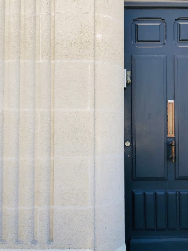 porte art déco bleu marine et mur en pierres bordelaises